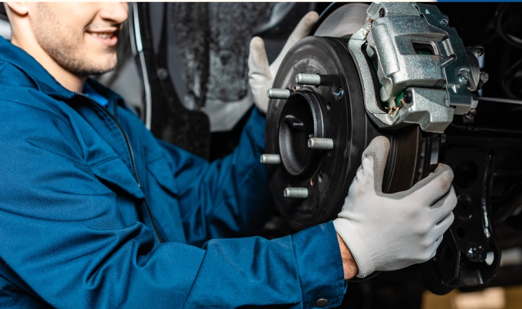 Mechanic removes the brake master cylinder of a car.