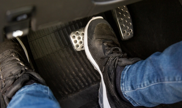 Driver's foot on the car's pedals.