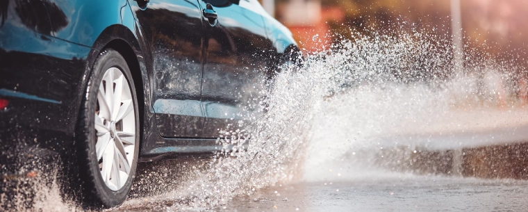 Water splashing as car drives through puddle.