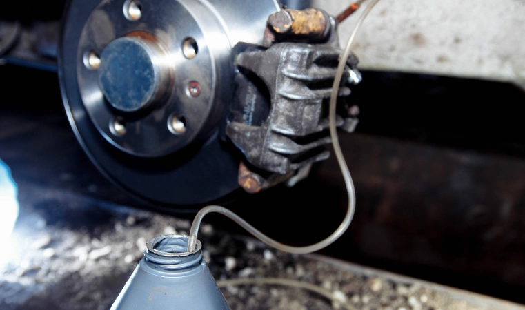 Bleeding brakes with a container of fluid.